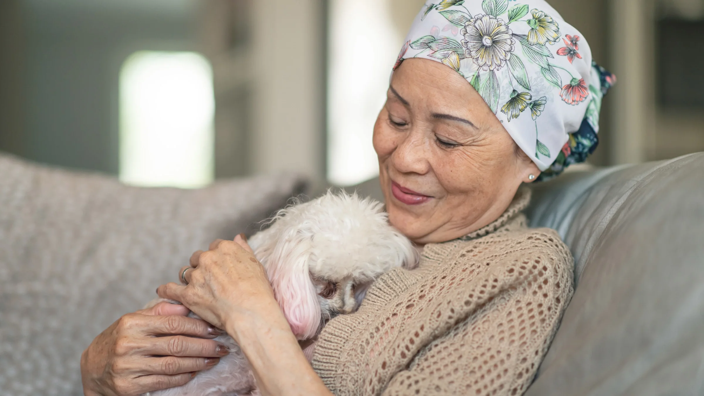 A cancer patient hugging a poodle.