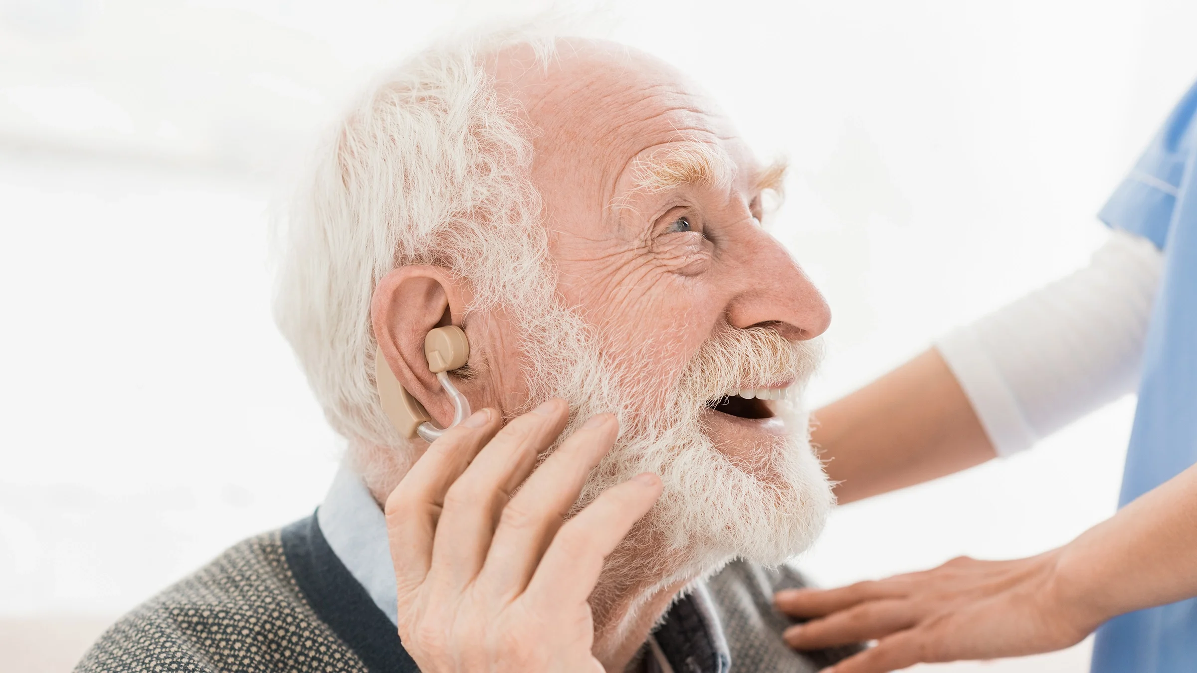 A close-up of an older man getting hearing aids.
