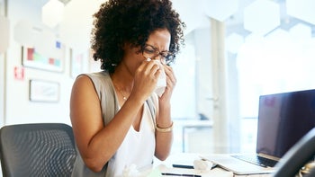 diphenhydramine: allergies: sneezing: woman blowing nose at desk-1065221726