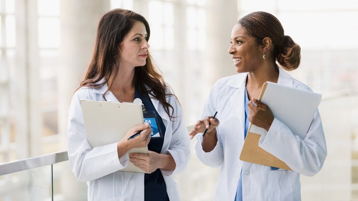 Two HCPs talking in a hospital corridor.