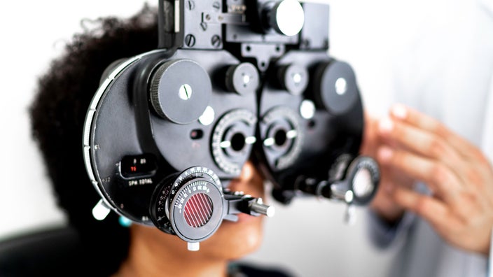 A woman gets her eyes checked during an eye exam. Refractive errors, like myopia and astigmatism, are common vision issues.
