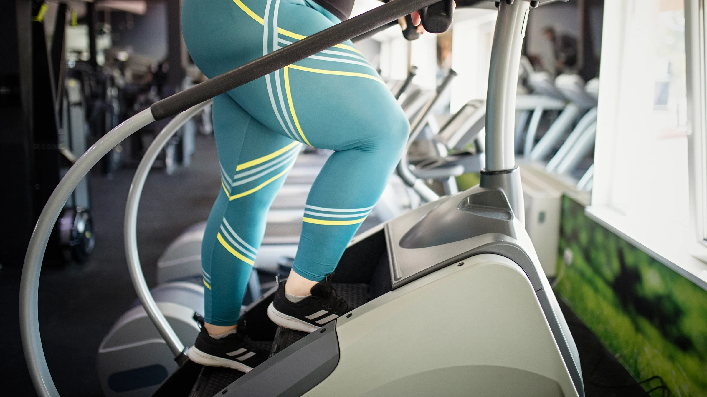 Woman at gym using stair-climber
