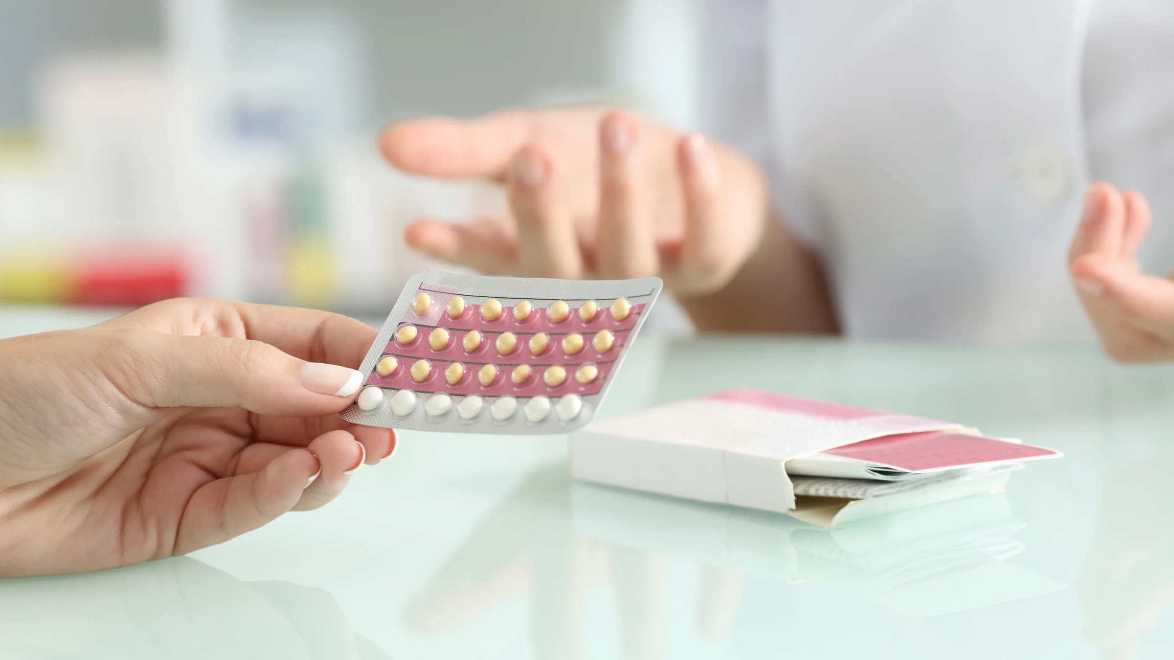 Close-up of a womans hand holding birth control pills.