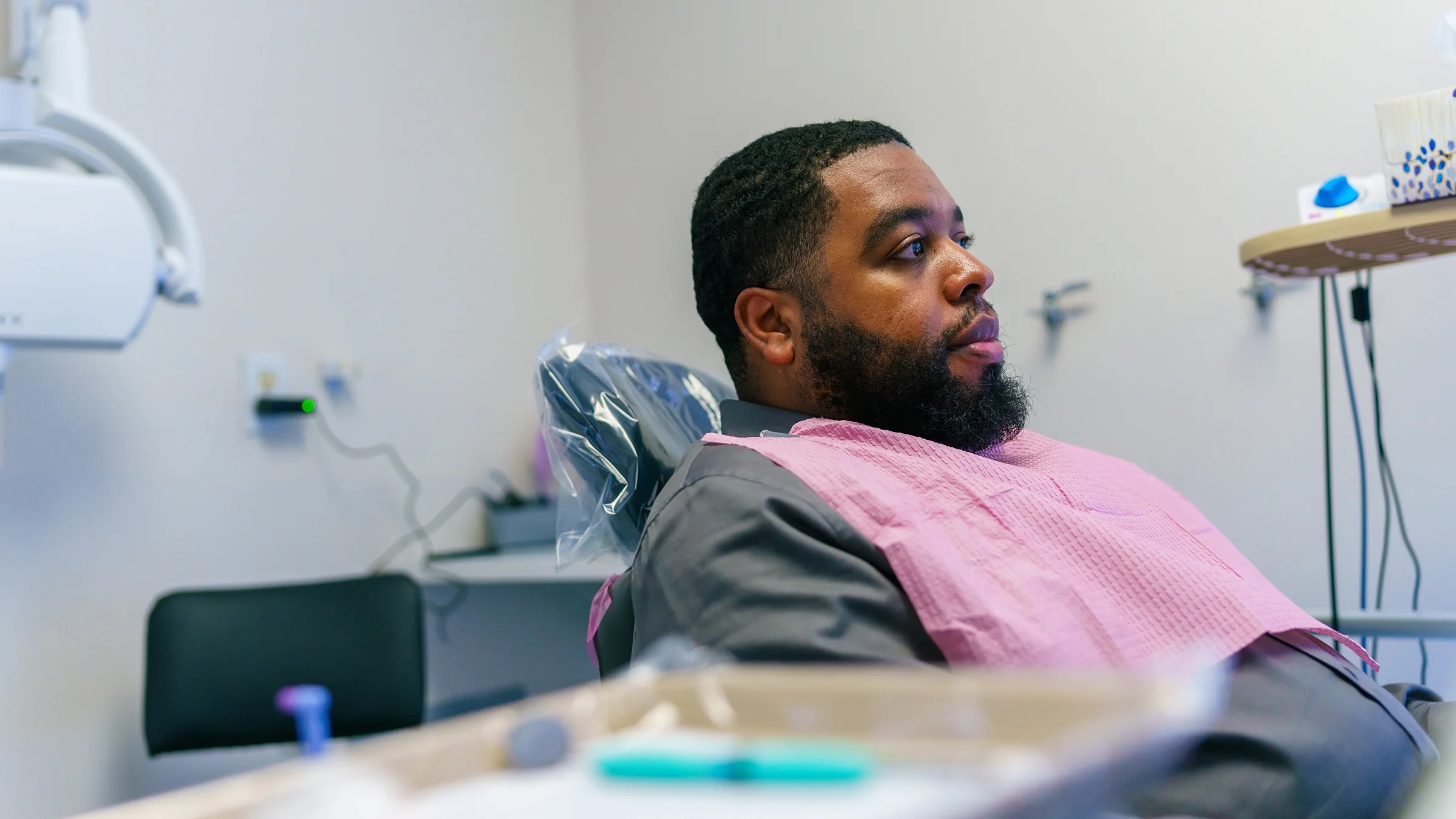 Patient sits in a dental chair waiting for an exam