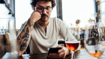 Mirtazapine: man reading phone at the bar 1248734221