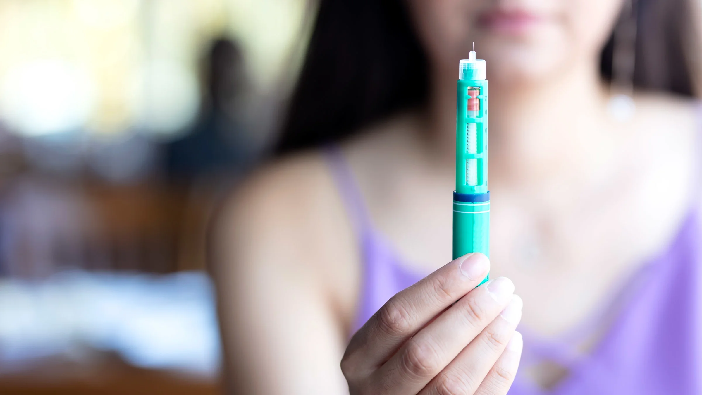 Close-up of someone holding an insulin pen.