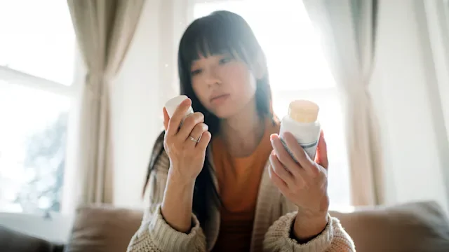 Health: Medication education: woman reading OTC label 1337117159
