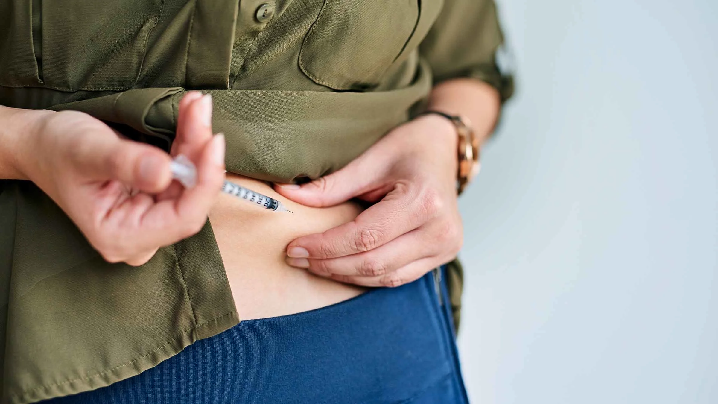 A woman is injecting herself with medication.