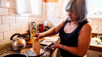 Diet Nutrition: senior woman cooking chicken breast 2158322853