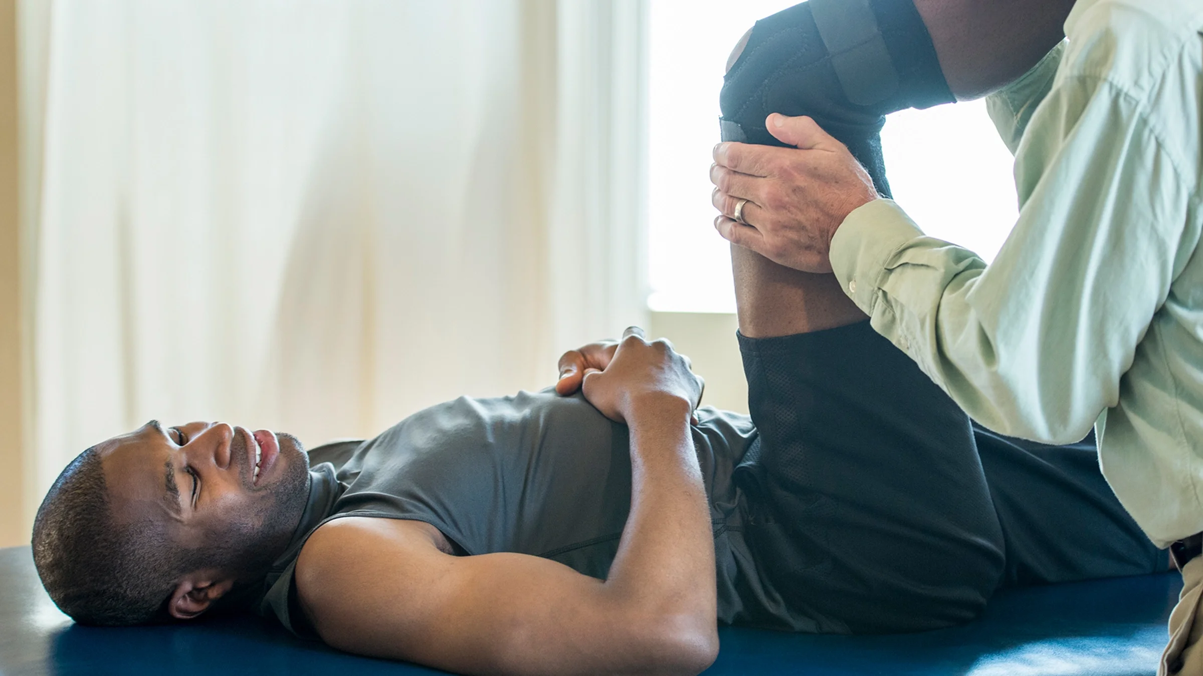 Man wearing a knee brace at physical therapy.