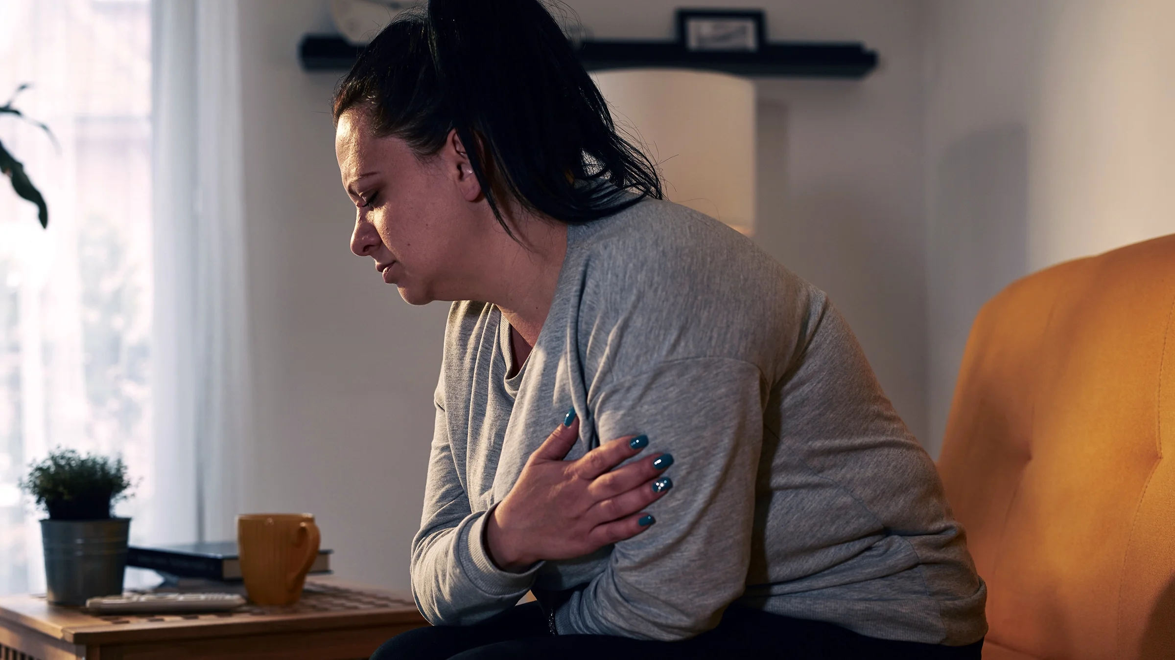 Woman with stomachache at home.