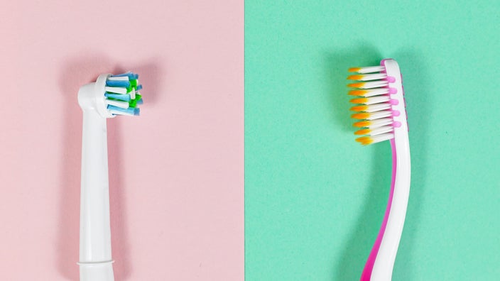 Electronic and traditional toothbrushes are shown side by side on a pink and green background.