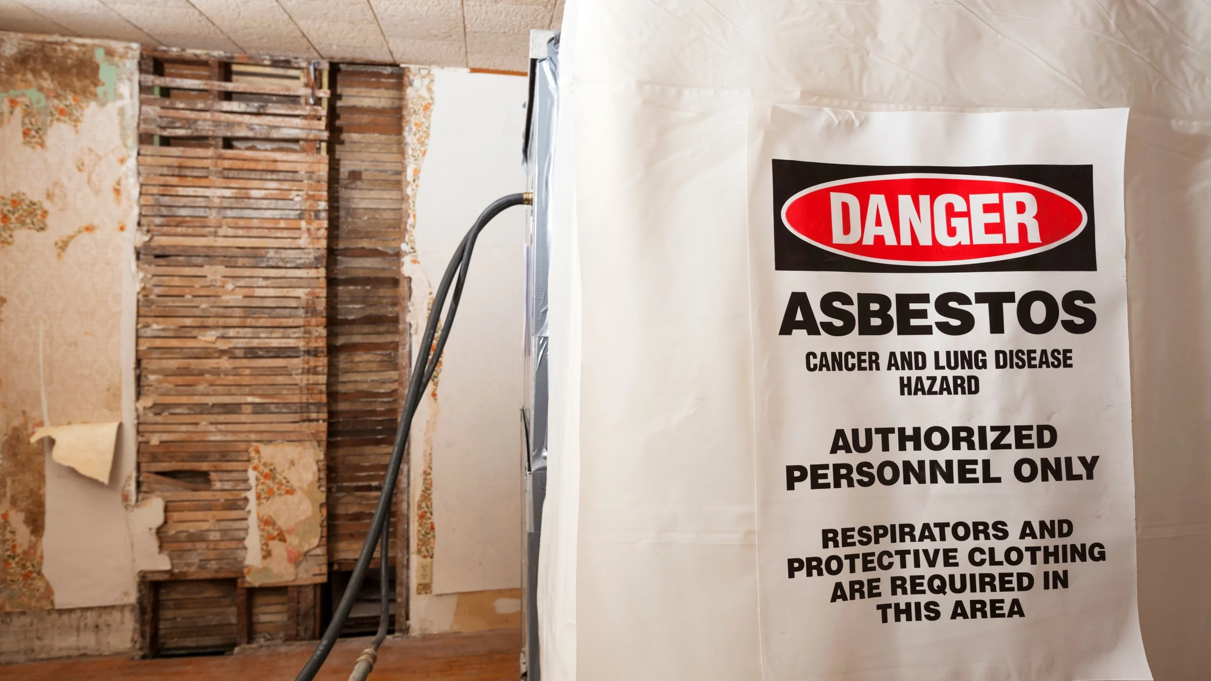 An asbestos removal sign is hanging in a home that’s under construction.