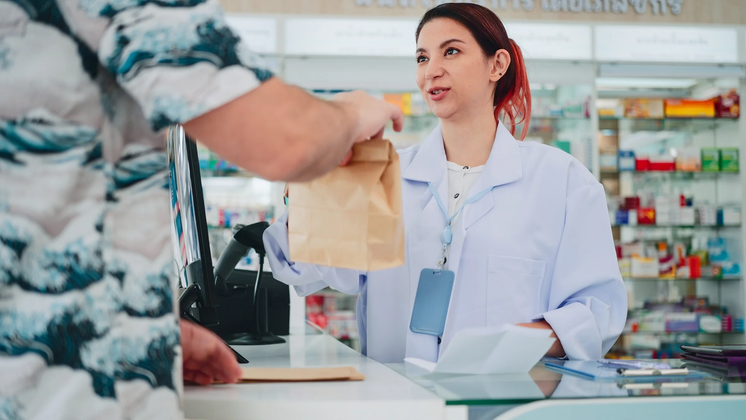 A pharmacist is pictured helping a customer.