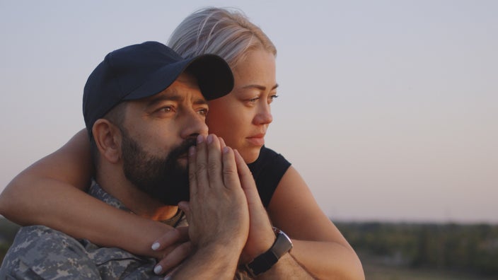 A person hugging their partner from behind.