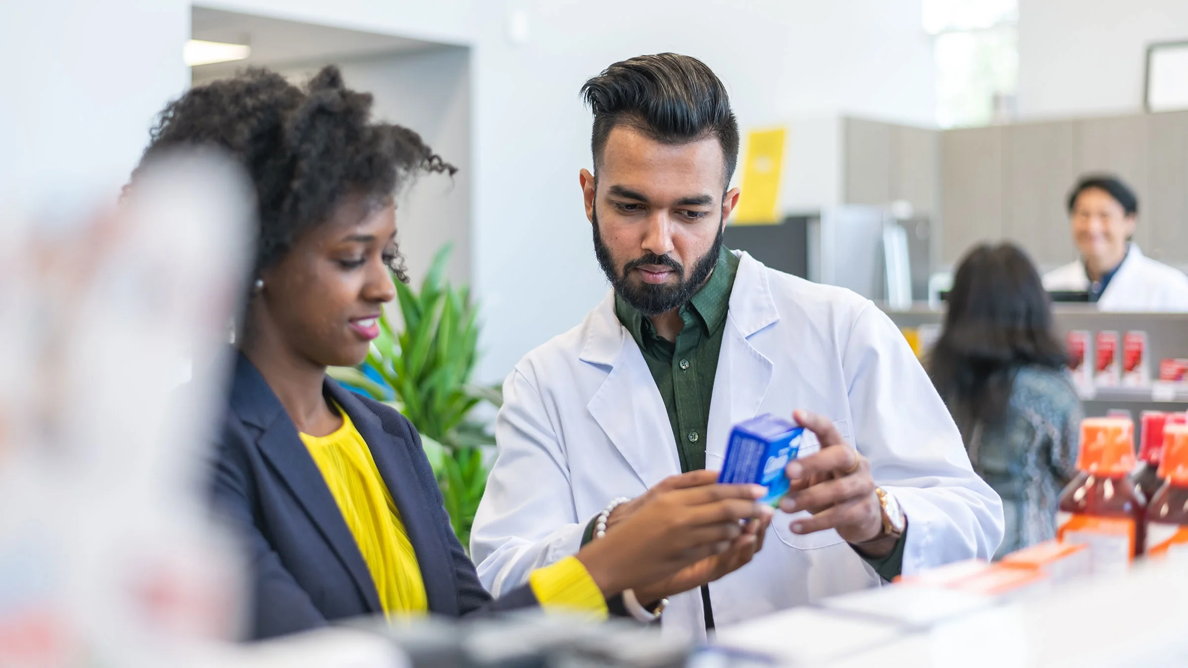 A pharmacist assists a woman with choosing a medication.