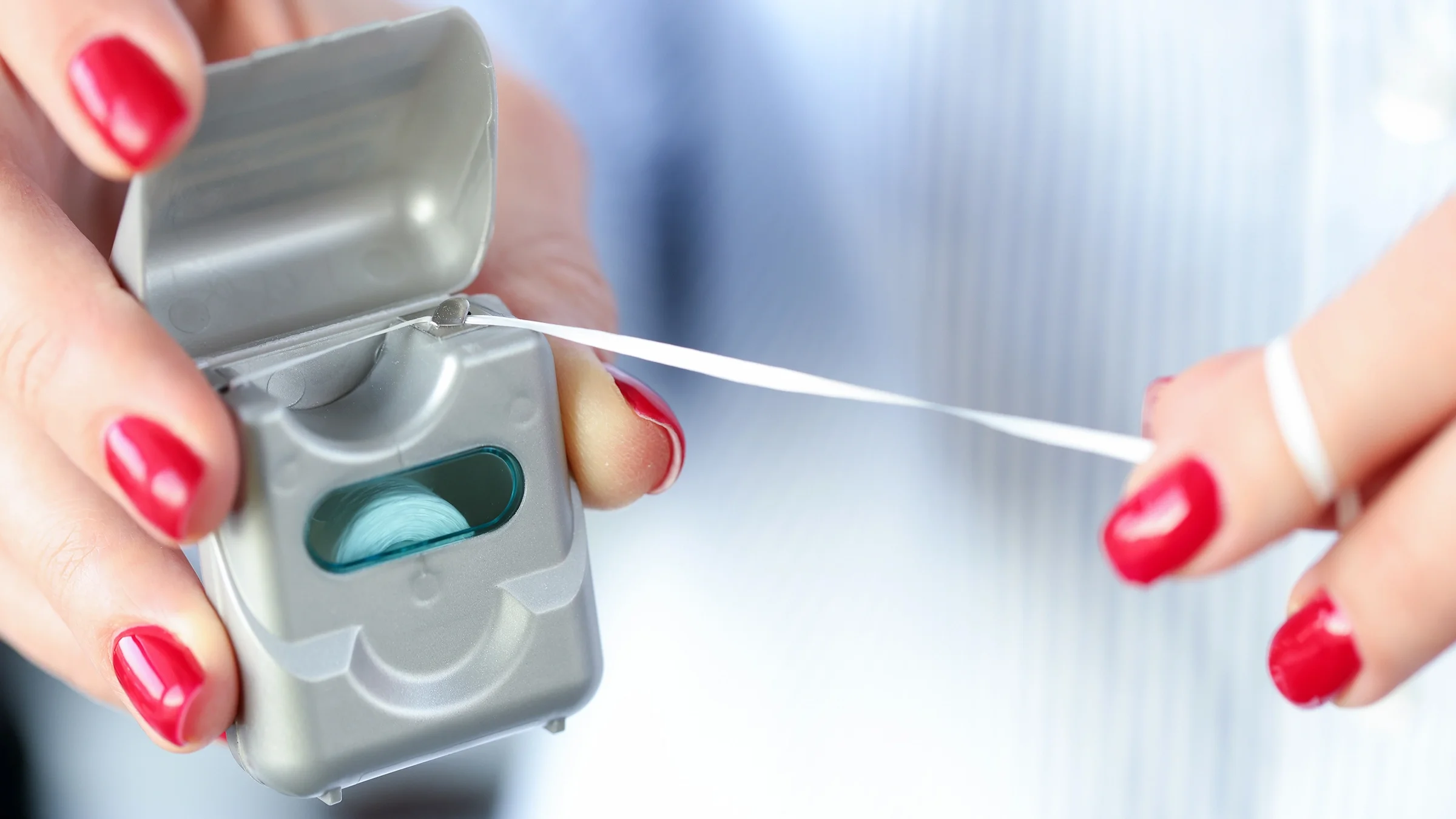 Close-up hands with dental floss.