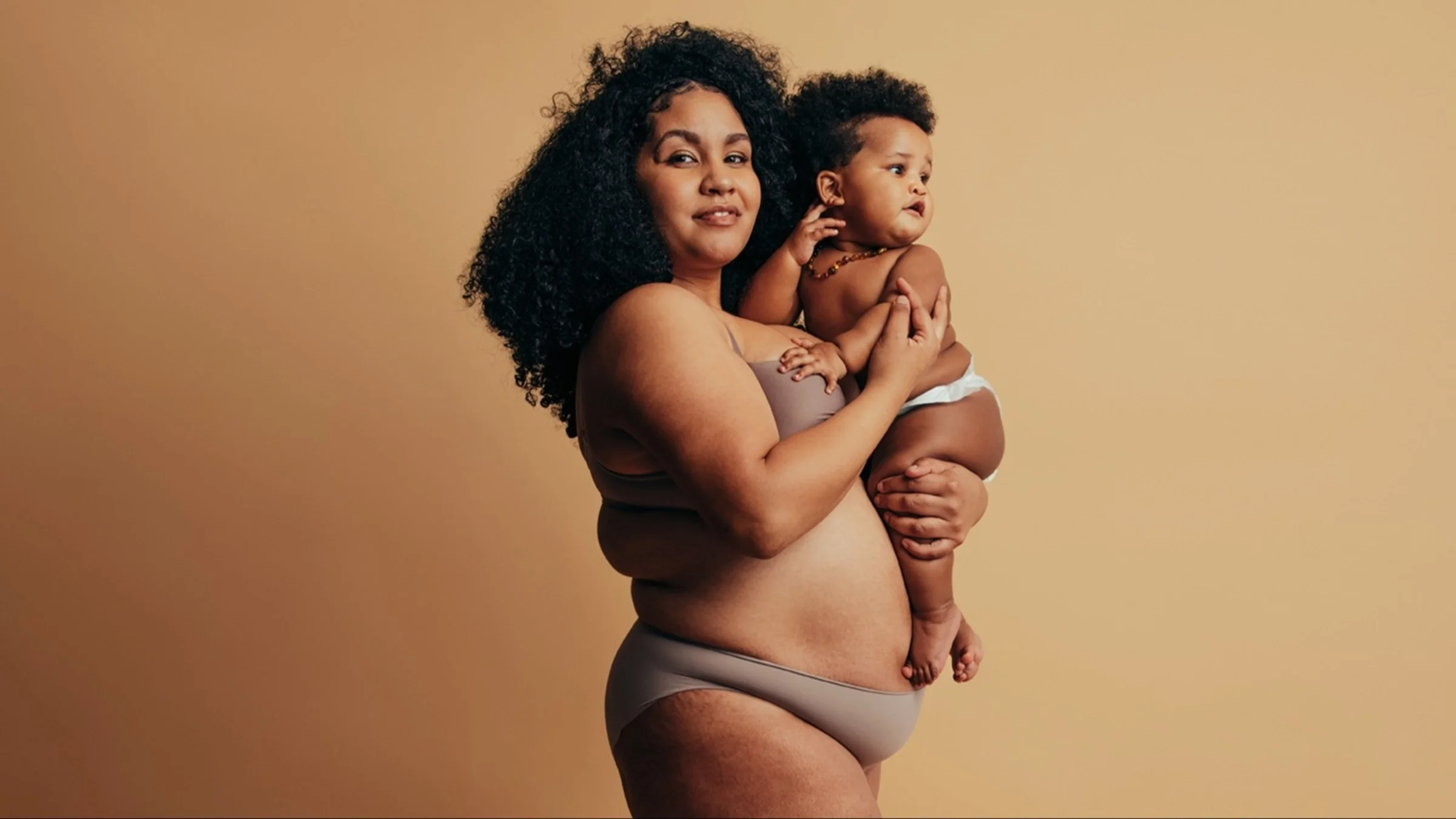Studio portrait of a Black woman and her baby.