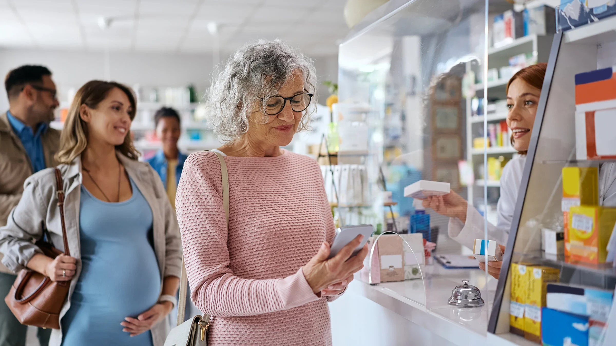 A woman uses her phone to pay at a pharmacy counter.
Drazen Zigic/iStock via Getty Images Plus