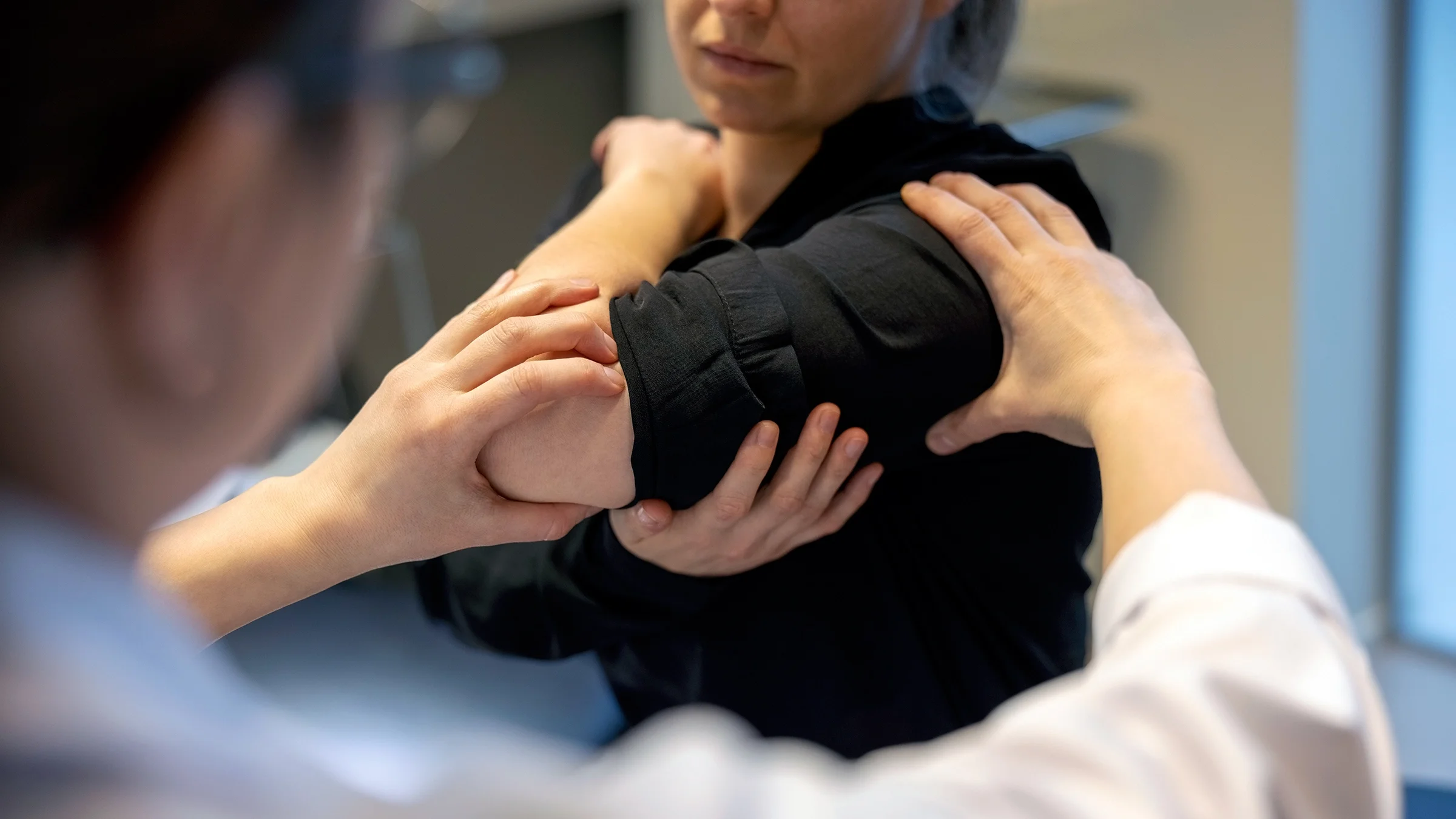 Close-up of a doctor examining the arm of a woman patient.