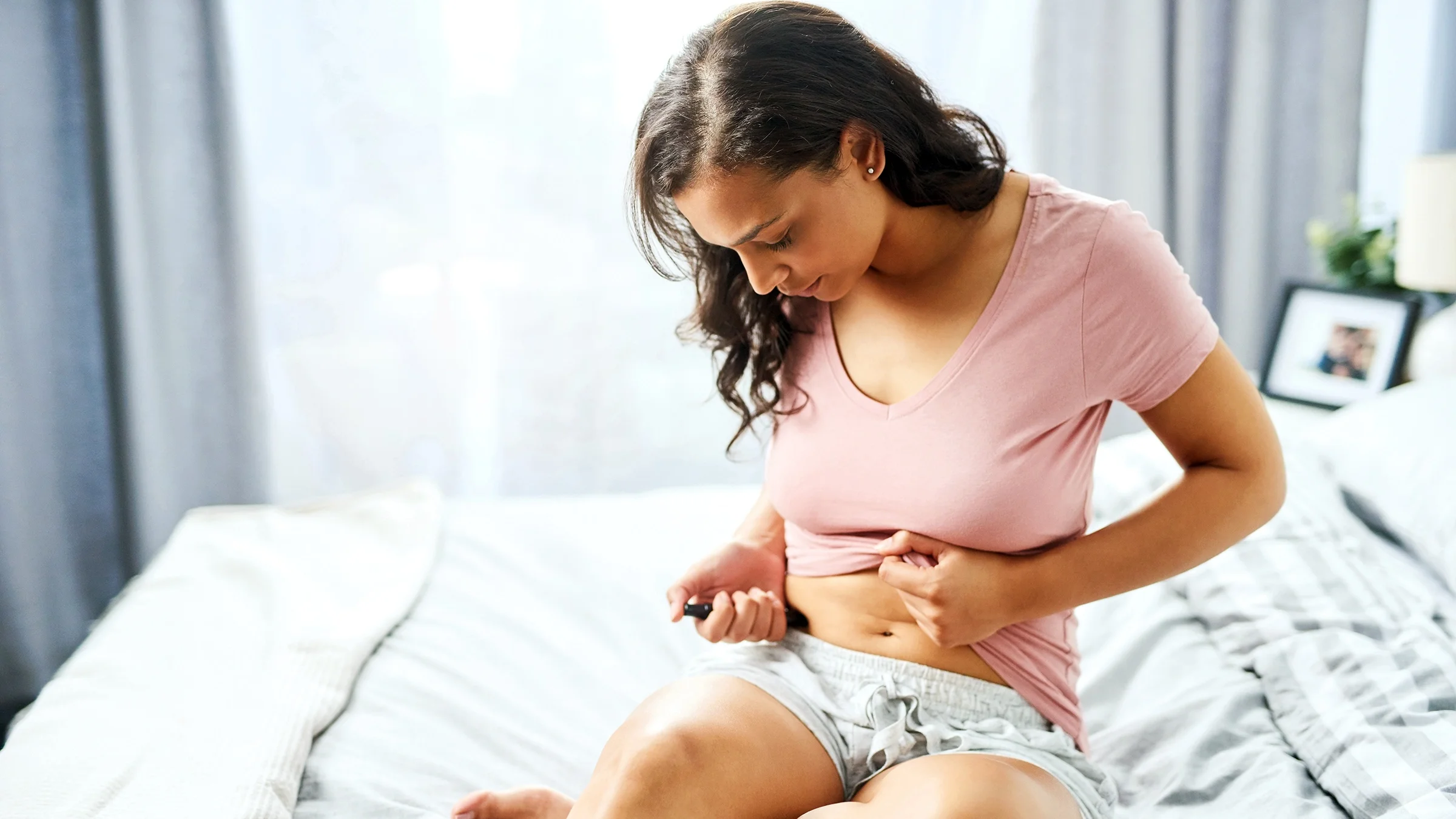 A woman injects her diabetes medication into her abdomen.
