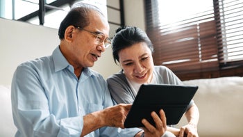 Personal finance: Changing Medicare plan: older couple looking at tablet 1156269410