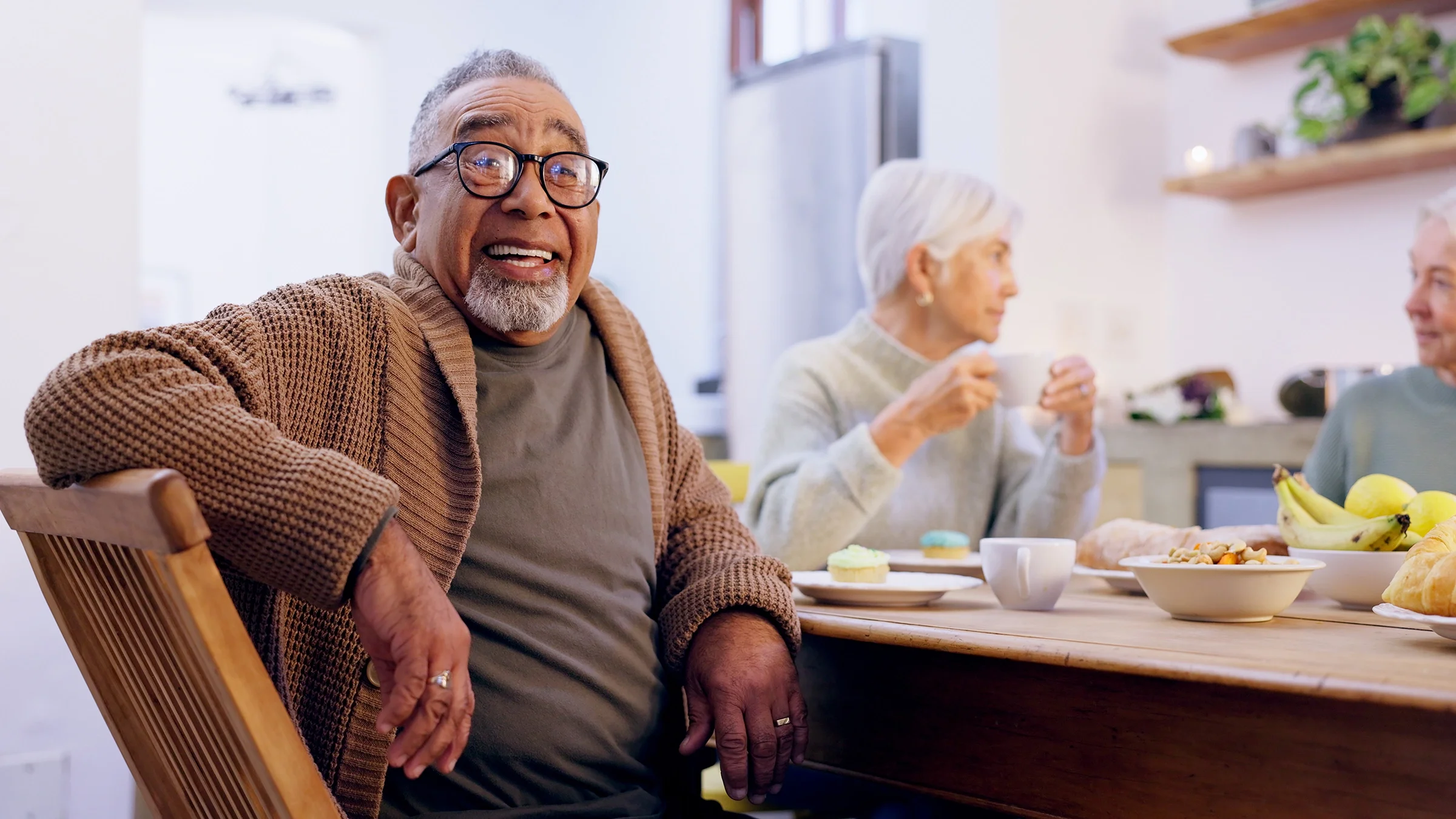 Portrait of an older man smiling at a dinner party.