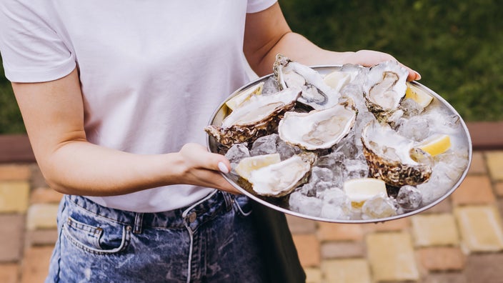 Close-up of fresh oysters on a plate with lemon and ice
