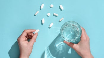 Health: Tardive dyskinesia: top view hand holding pill and water 1293450497