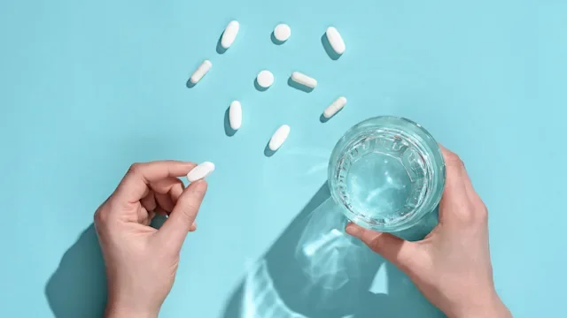 Health: Tardive dyskinesia: top view hand holding pill and water 1293450497