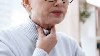 eosinophilic-esophagitis: woman rubbing throat 1289371396