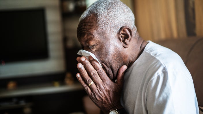 Senior man blowing his nose