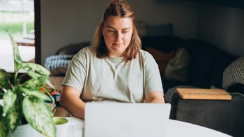 Savings: woman working on laptop at home 2163730573