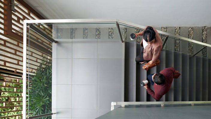 Overview shot of two colleagues walking in the stairwell.