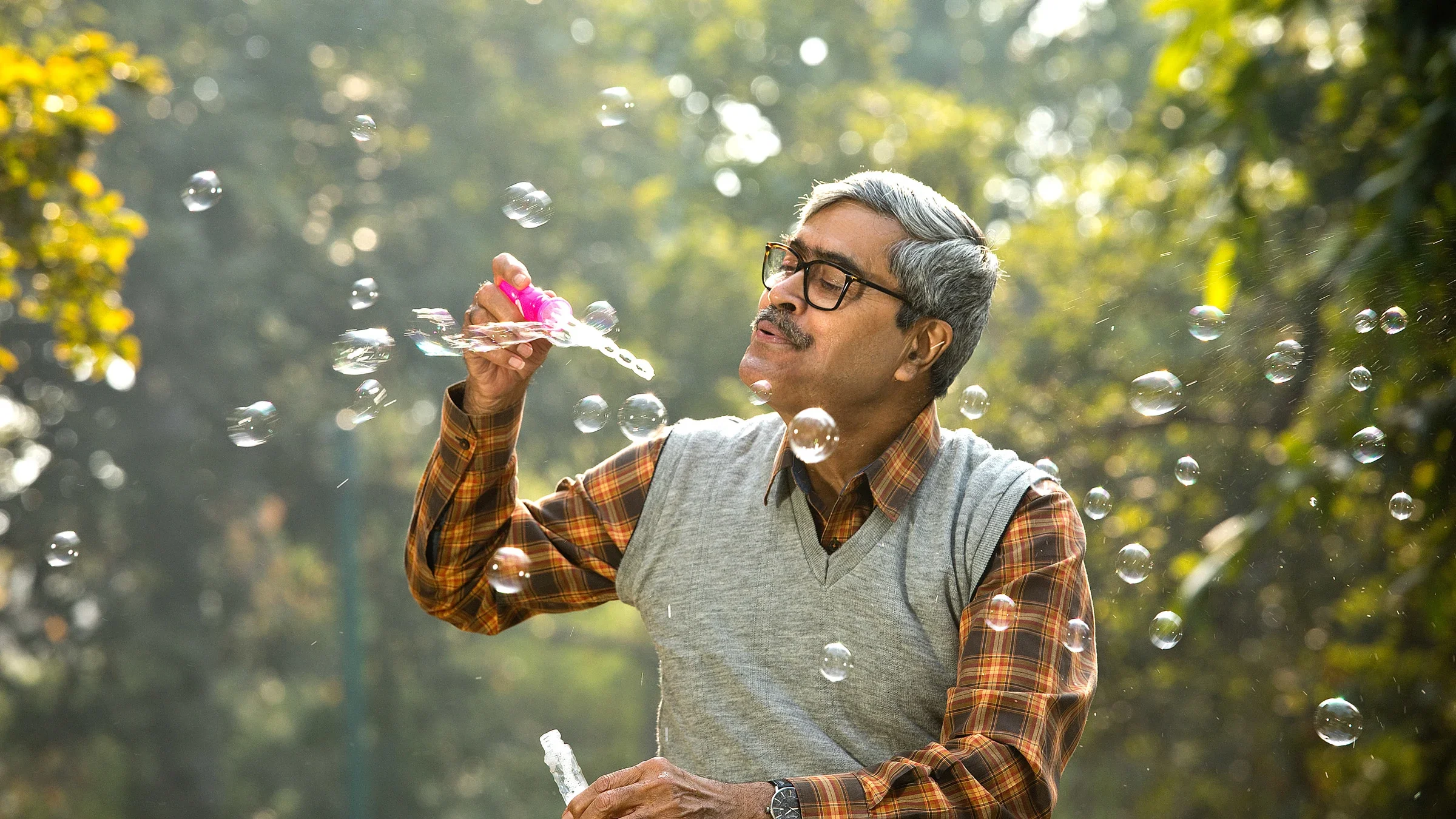 A senior adult blowing bubbles.
triloks/E+ via Getty Images