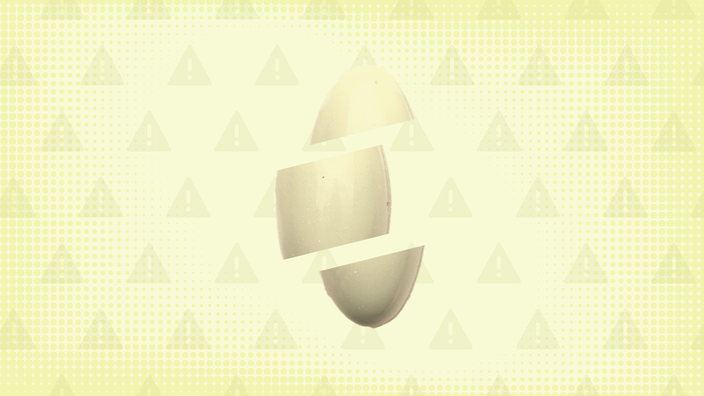Light-yellow background with texture and warning sign pattern. In the center is a yellow soft gel pill cut into thirds. 