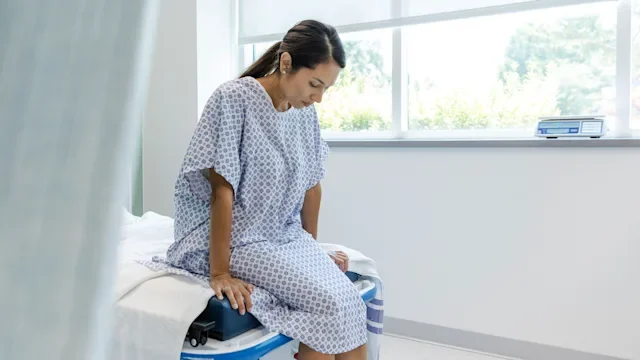 Sexual Health: woman in hospital robe waits for test results 1729780223