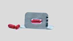 Individually packaged red pill with other pills next to it.
Fahroni/iStock via Getty Images
