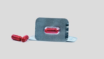 Fluconazole: Interactions: red packaged pill gray background-962031162