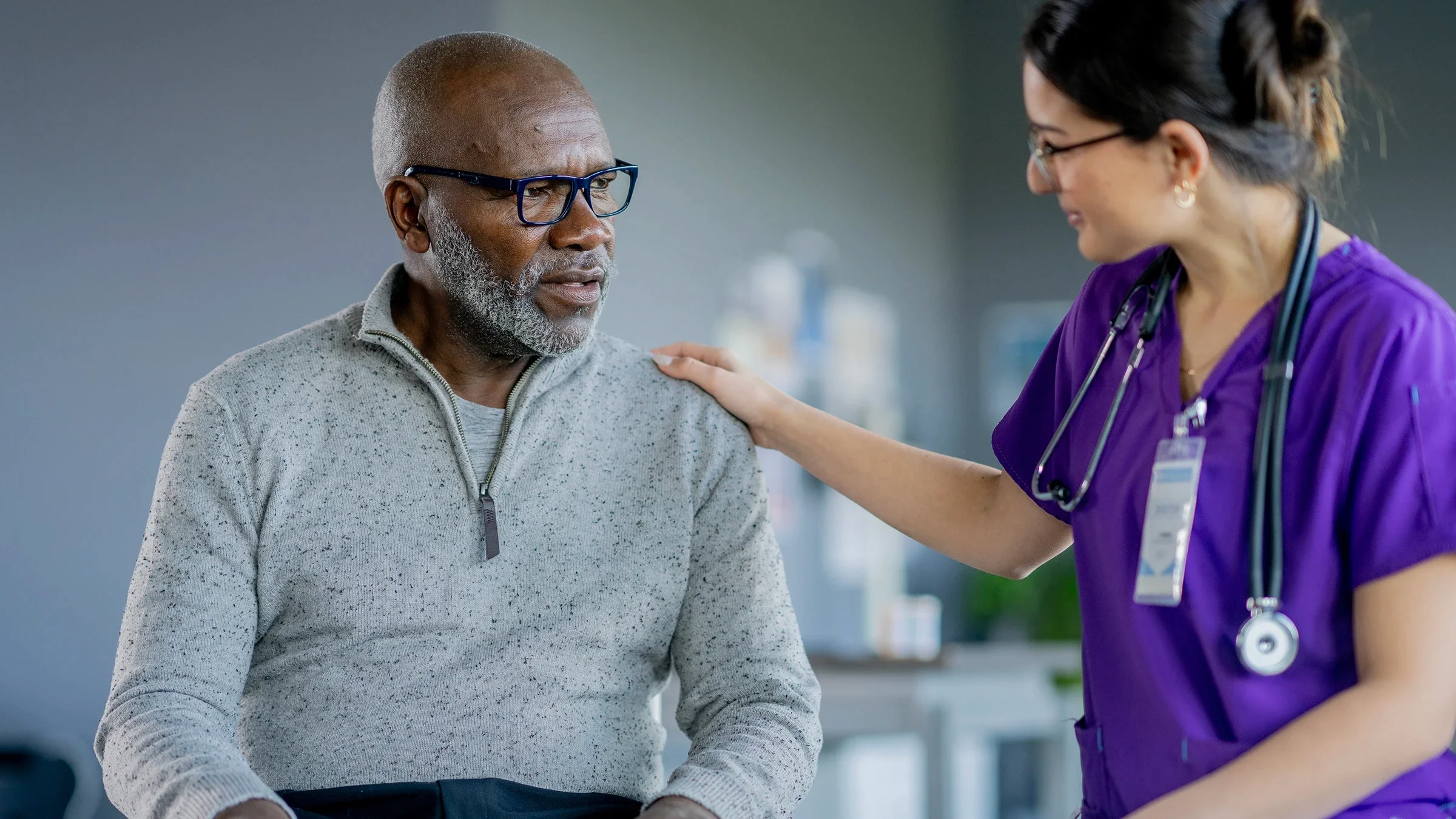A man talks with a healthcare professional at a medical appointment.