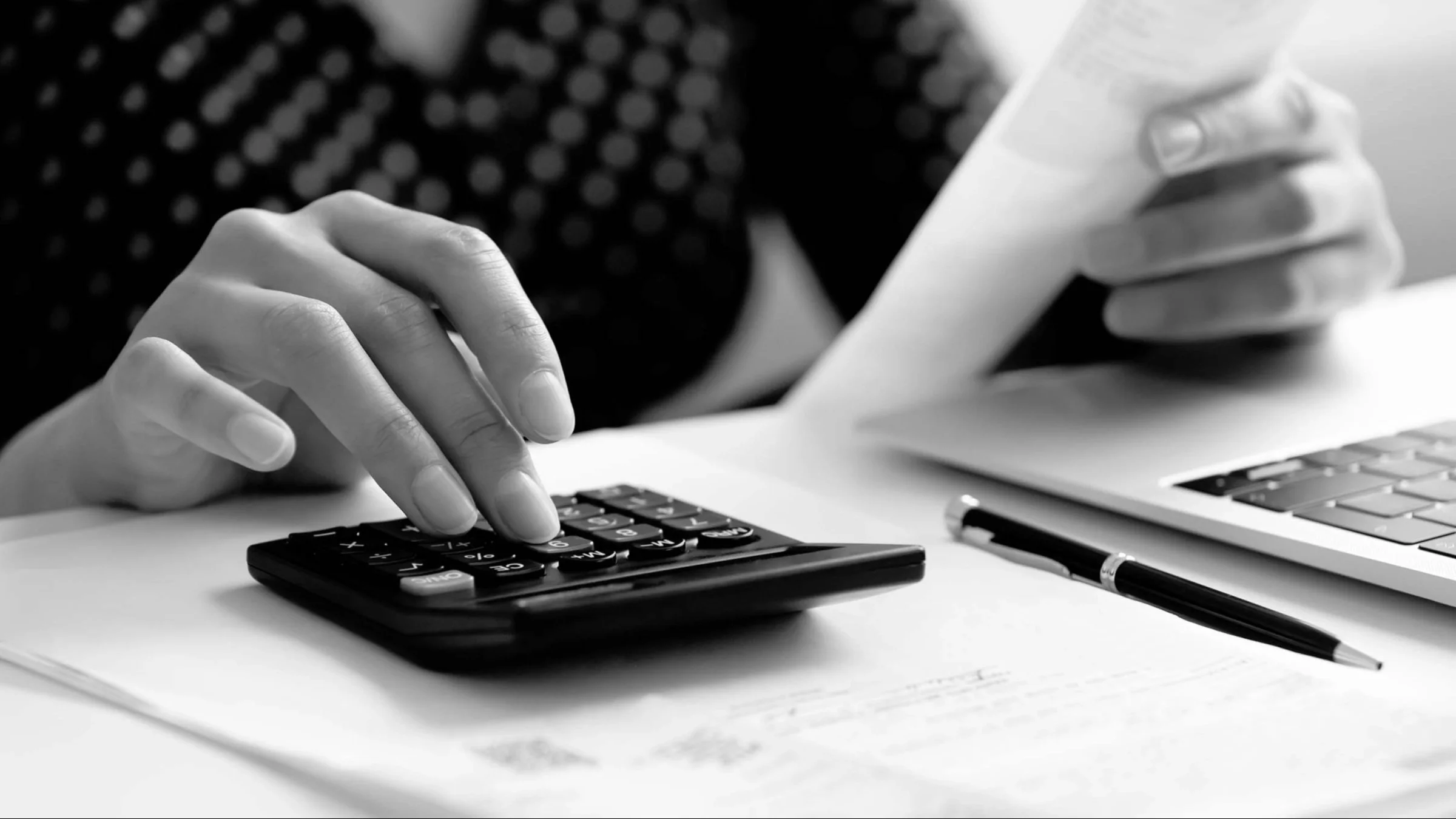 Close-up of someone using a calculator while going over their bills.
