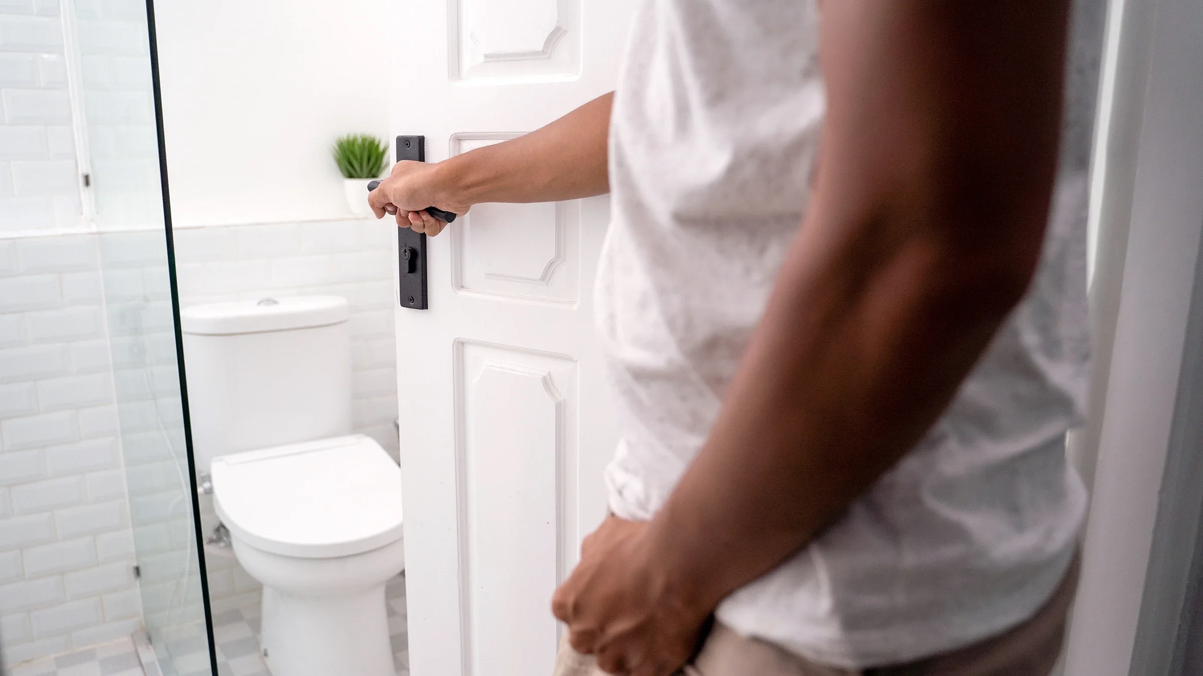 A man opens a bathroom door.