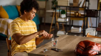 Men's Health: man taking medication at home 1960400023