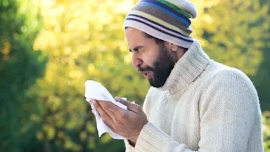 A man sneezing into a tissue.
SolStock/E+ via Getty Images  