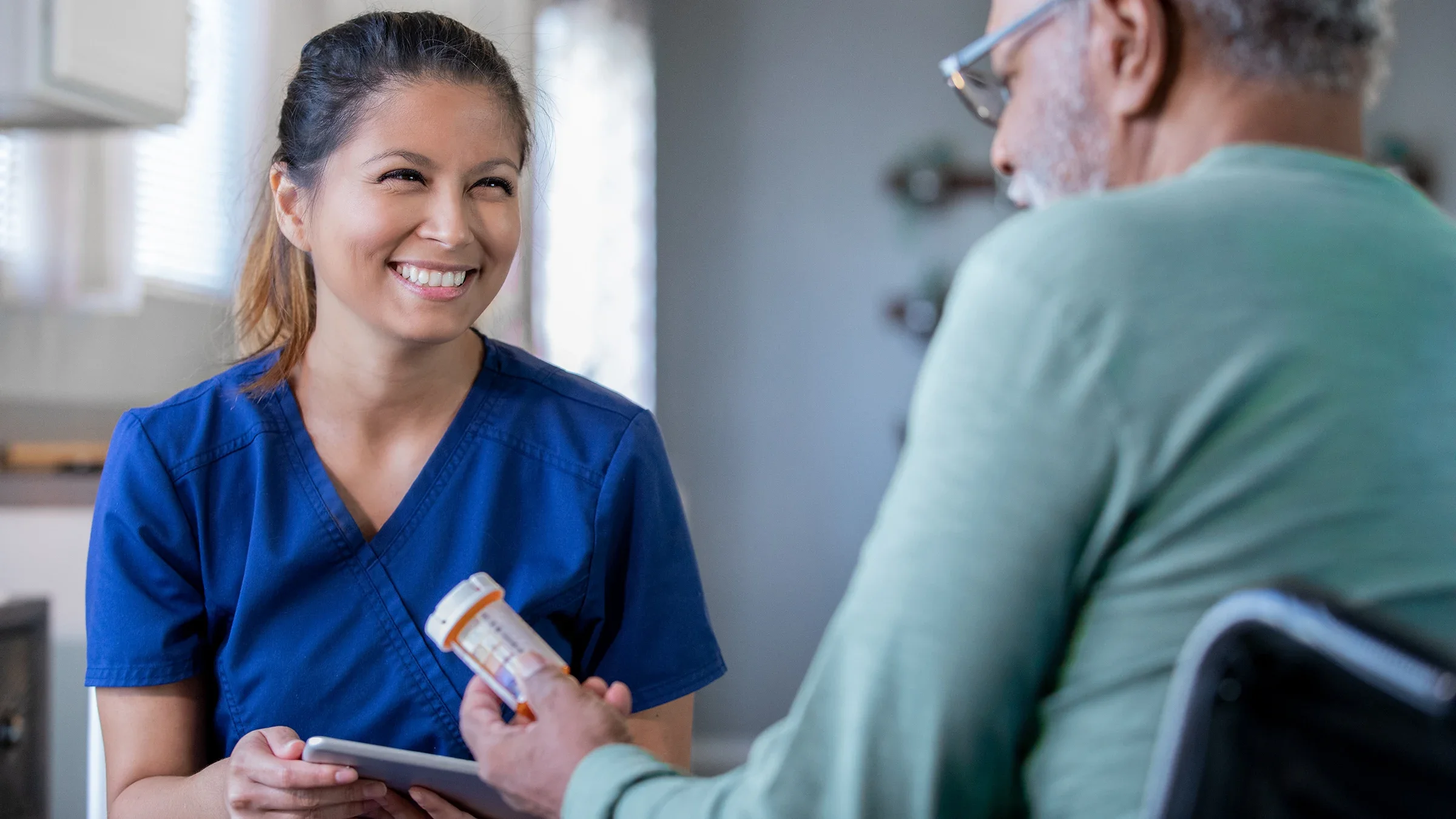 Nurse smiling at patient as they review medications with them.
Courtney Hale/E+ via Getty Images