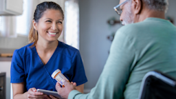 Nurse smiling at patient as they review medications with them.
Courtney Hale/E+ via Getty Images