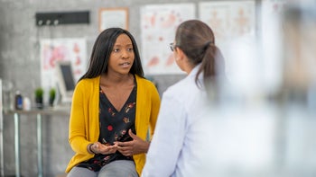 Fertility: Women's Health: woman convo with doctor 1134371124
