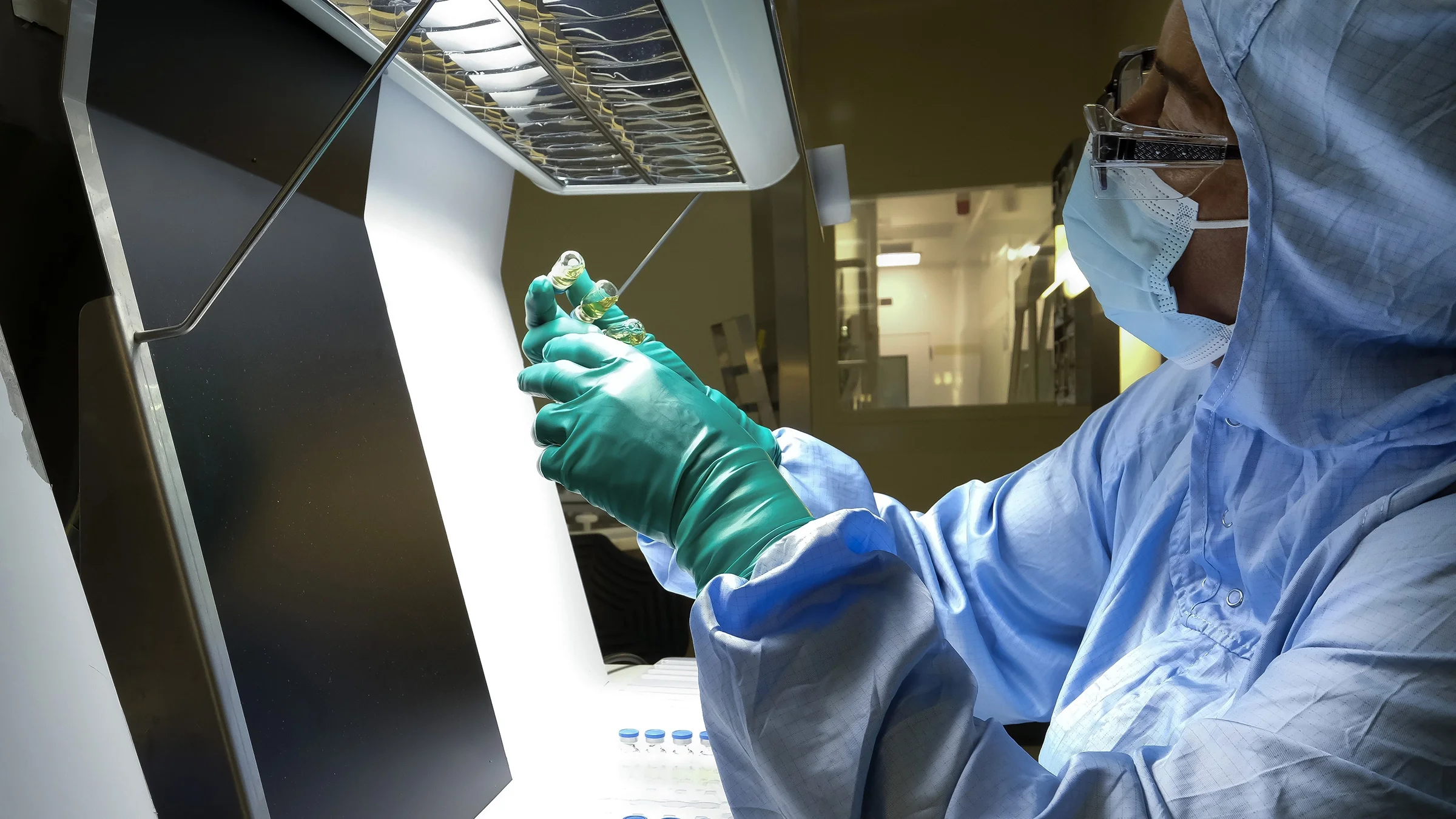 A manufacturing team member works on the production line for a vaccine.