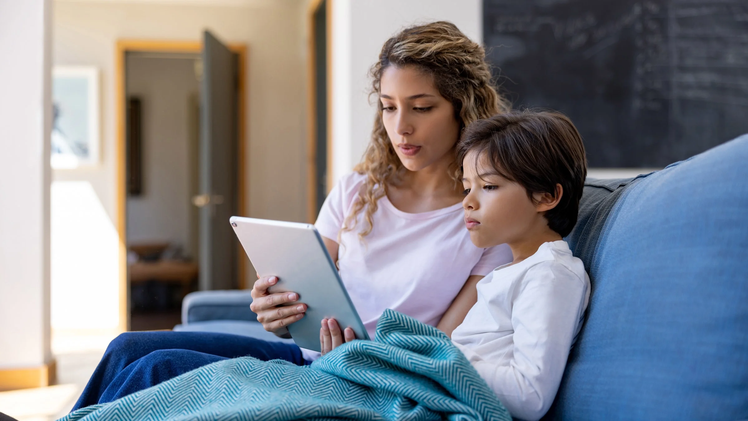 A aparent and child on a telehealth call together.