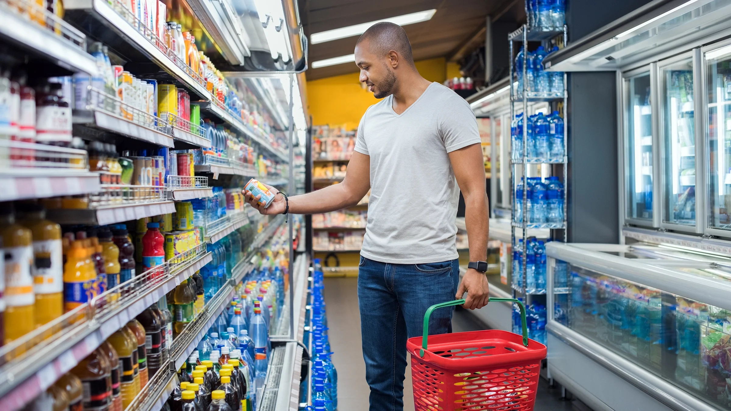 A man reads a food label in the supermarket.